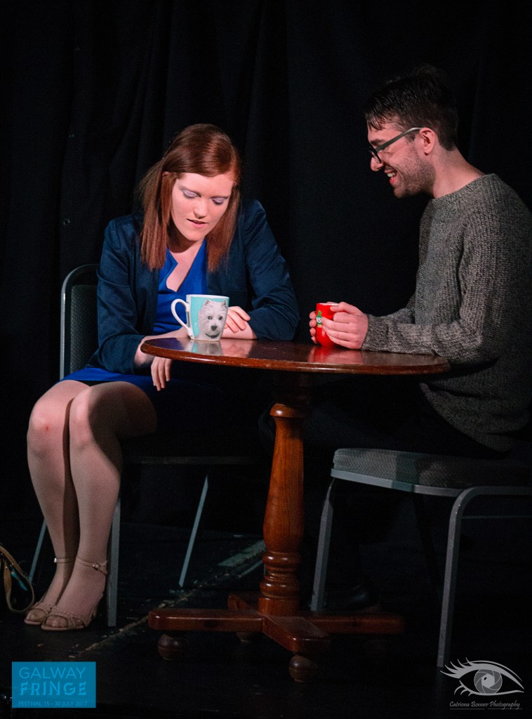 Two actors at table drinking tea